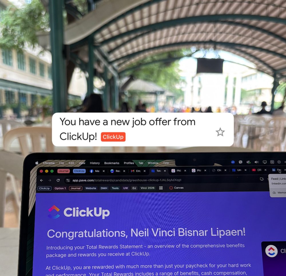A laptop on a campus table showing a ClickUp offer page, under a notification that reads: You have a new job offer from ClickUp!